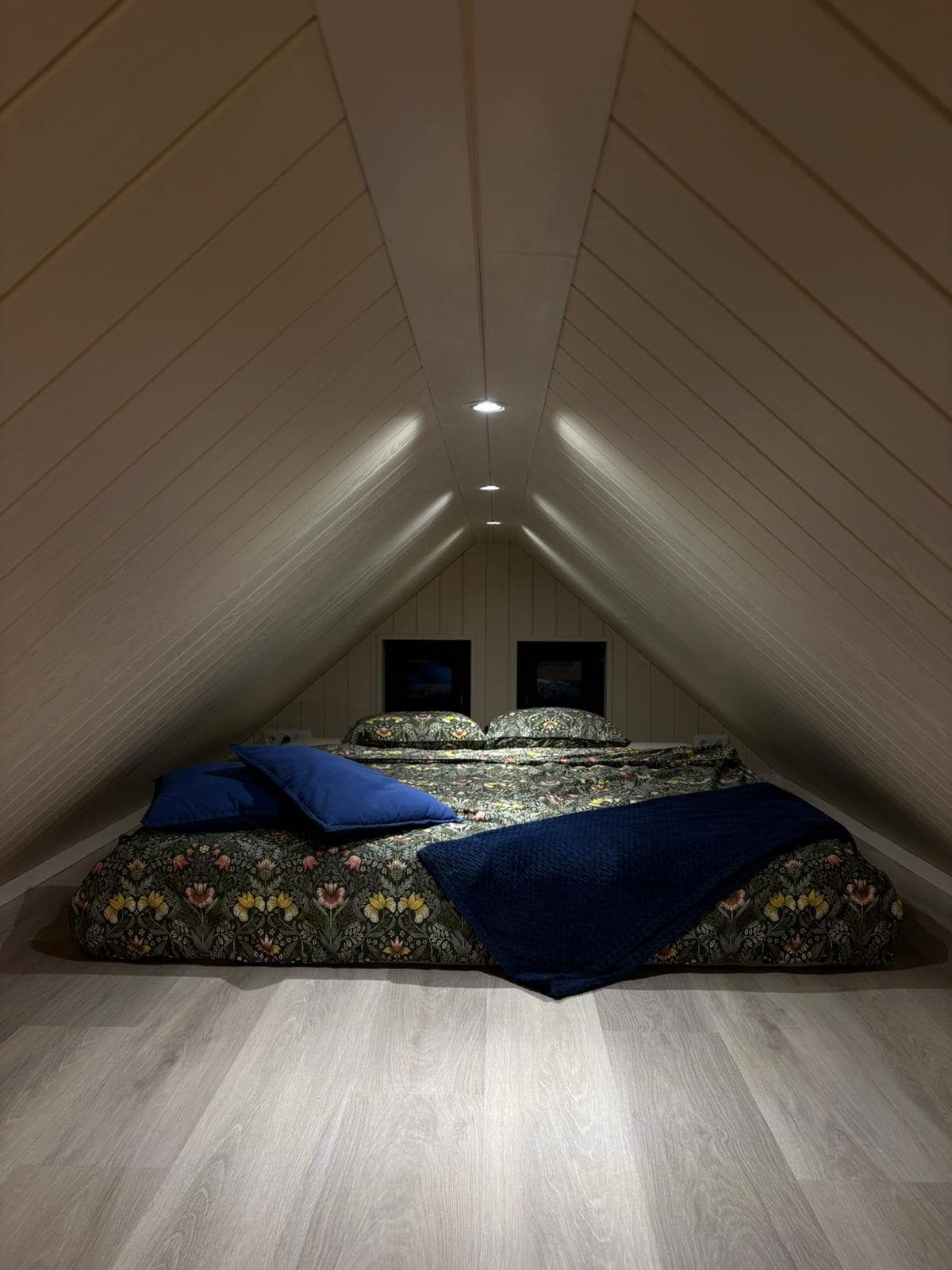 A-frame loft bedroom with floral bedding